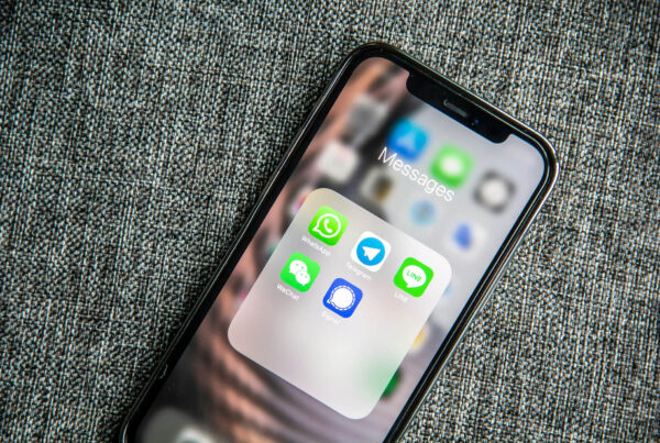 Teléfono móvil con apps de mensajería como WhatsApp, Telegram y LINE, usado en negocios para respuestas automáticas